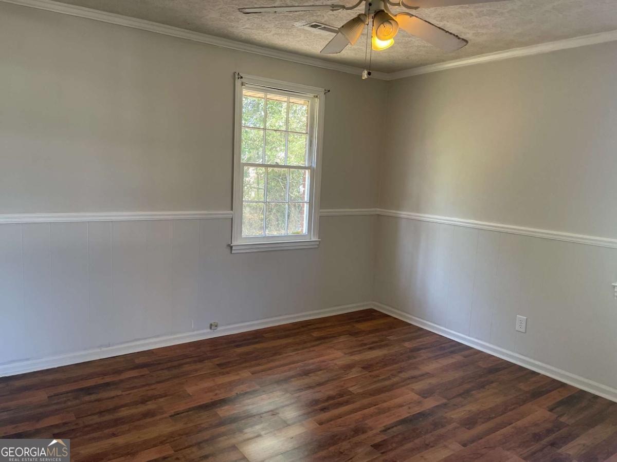 412 West 4th Street Vidalia, GA 30474 - Photo 9 of 23 an empty room with wooden floor and windows