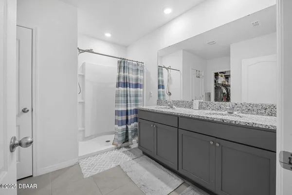 a bathroom with a granite countertop sink a mirror and a shower