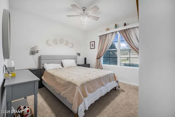 a bedroom with a bed and a large window