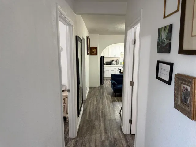 a view of a hallway with wooden floor and staircase