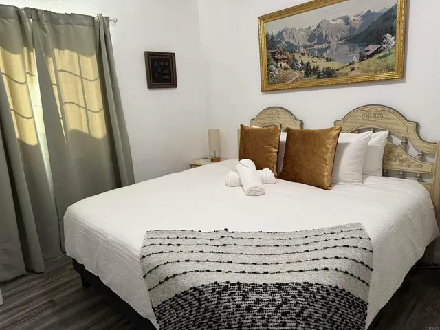 a bedroom with a bed and a painting on the wall