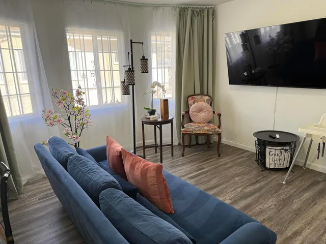 a living room with furniture a flat screen tv and a window