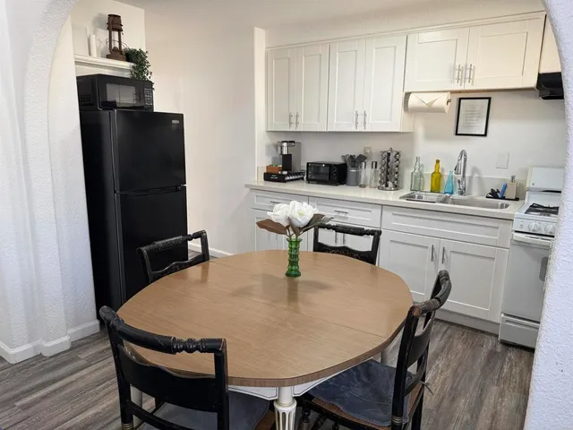 a kitchen with stainless steel appliances a dining table chairs and granite counter tops
