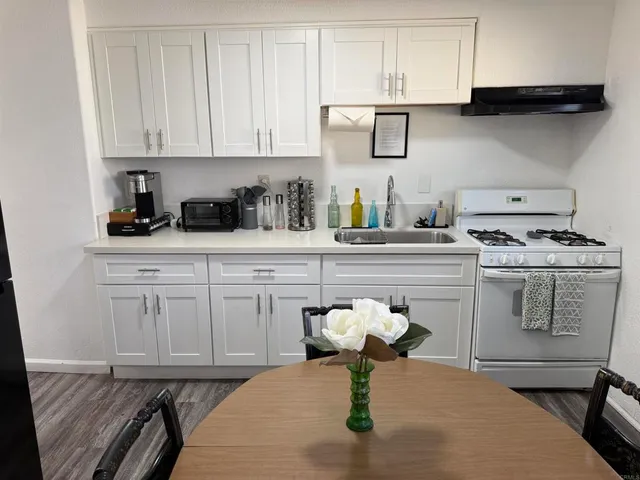 a kitchen with white cabinets appliances and a sink