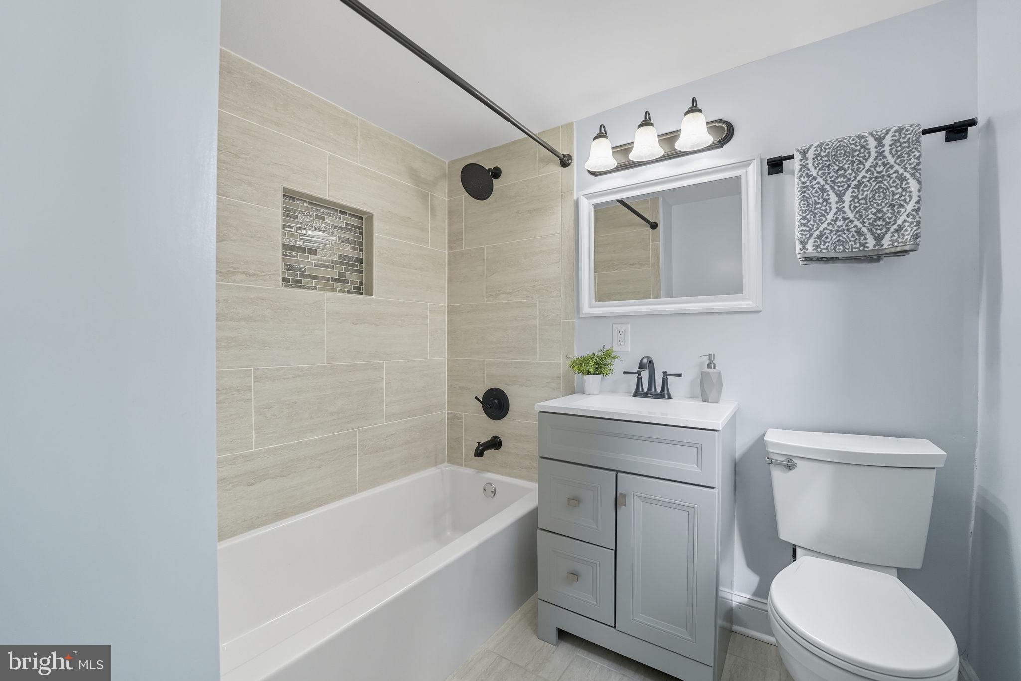 3708 Woodridge Avenue Silver Spring, MD 20902 - Photo 30 of 38 a bathroom with a toilet sink vanity tub and mirror