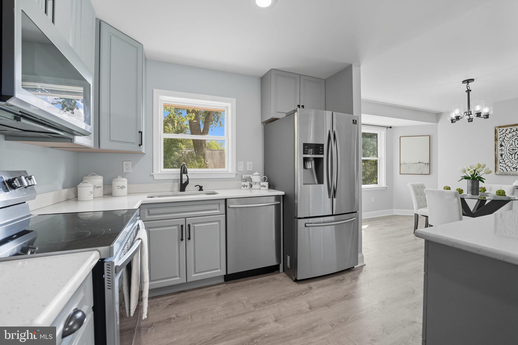 3708 Woodridge Avenue Silver Spring, MD 20902 - Photo 9 of 38 a kitchen with kitchen island a sink stove and refrigerator