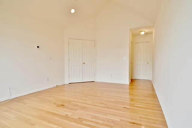 a view of an empty room and wooden floor
