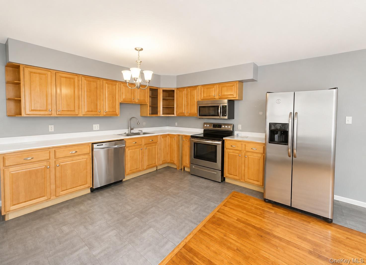 43 Glenmere Homesites Road, Unit 2F Florida, NY 10921 - Photo 5 of 15 Kitchen featuring extensive light wood cabinetry, white countertops, stainless steel appliances, and a gray tile-patterned floor
