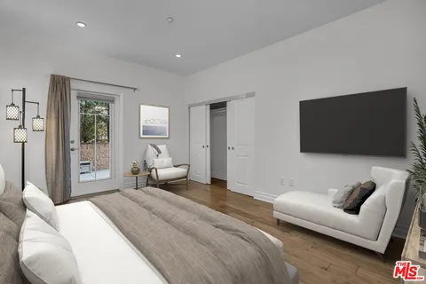 a bedroom with bed and a flat screen tv