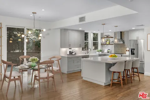 a kitchen with a dining table chairs and chandelier