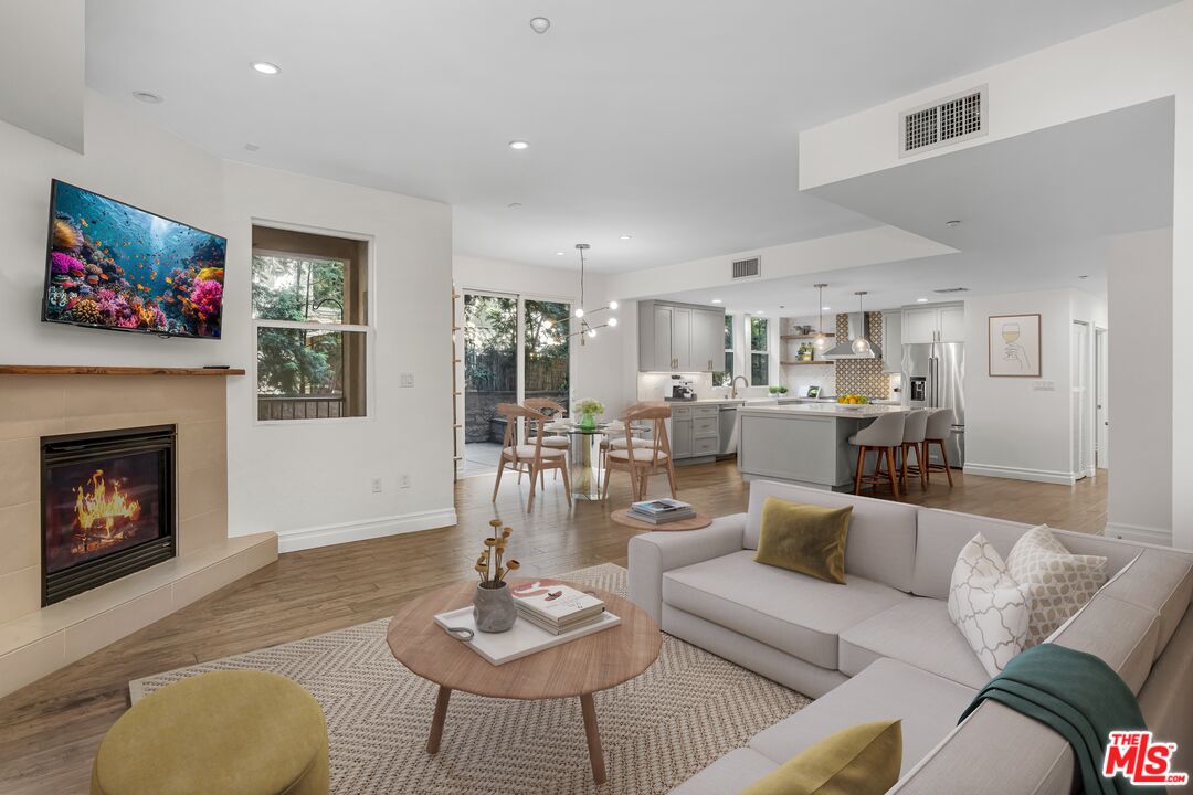 1248 North Laurel Avenue, Unit 103 West Hollywood, CA 90046 - Photo 4 of 25 a living room with furniture kitchen view and a fireplace