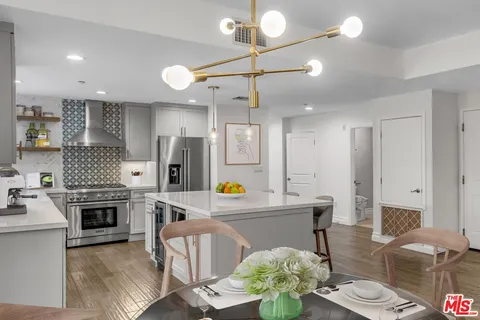 a living room with stainless steel appliances kitchen island granite countertop furniture and a fireplace