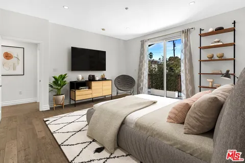 a bedroom with a bed and a flat screen tv