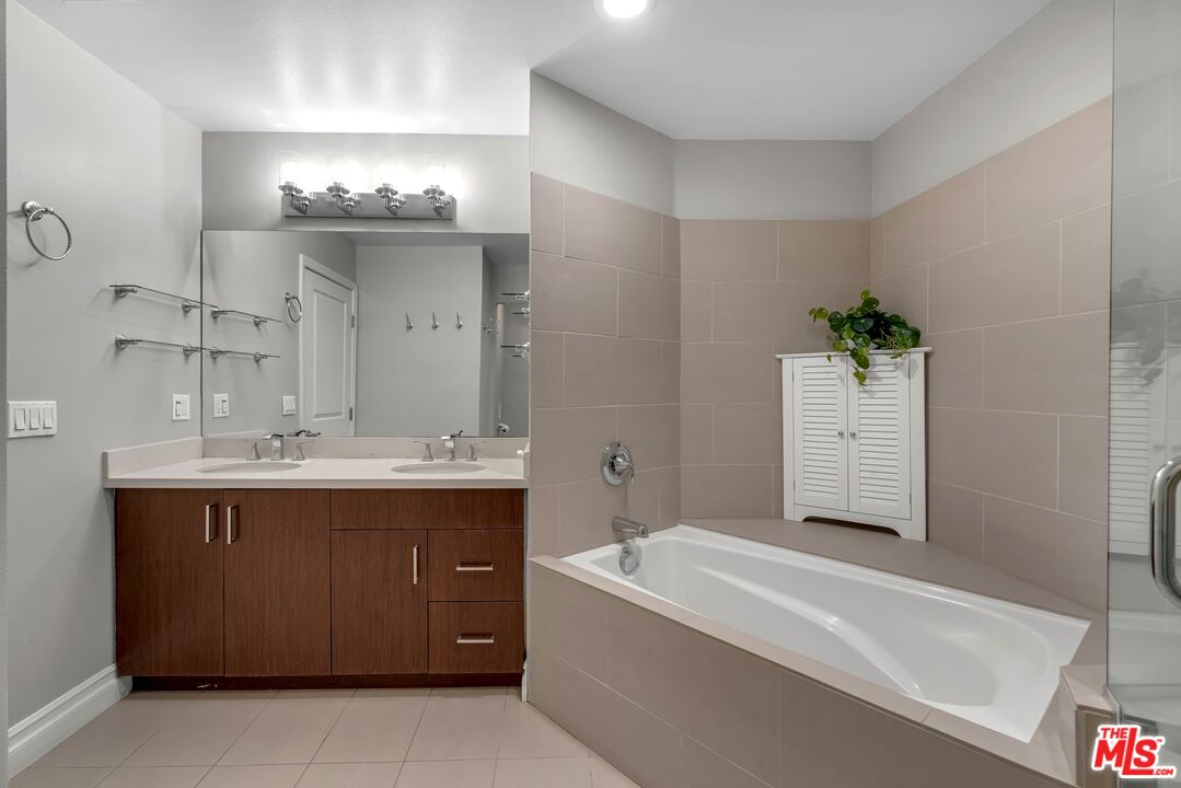 1248 North Laurel Avenue, Unit 103 West Hollywood, CA 90046 - Photo 9 of 25 a bathroom with a tub sink and mirror