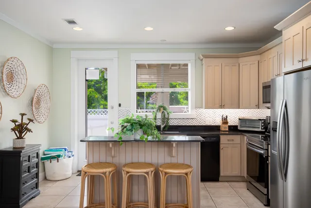 a kitchen with granite countertop a sink a counter space and stainless steel appliances