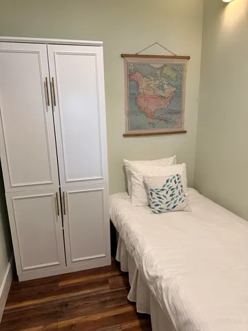 a bedroom with a bed and a refrigerator
