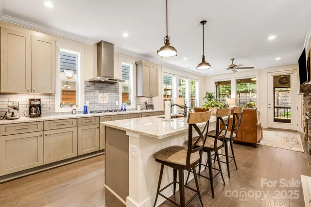 a open kitchen with stainless steel appliances granite countertop a stove and a wooden floors
