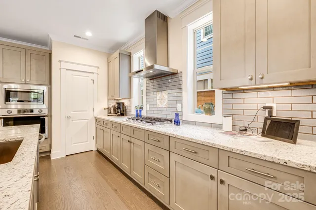 a kitchen with stainless steel appliances white cabinets and a window