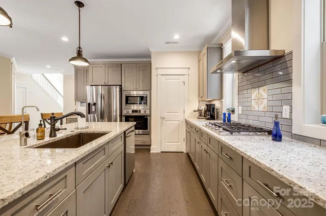 a kitchen with stainless steel appliances granite countertop a sink stove and refrigerator
