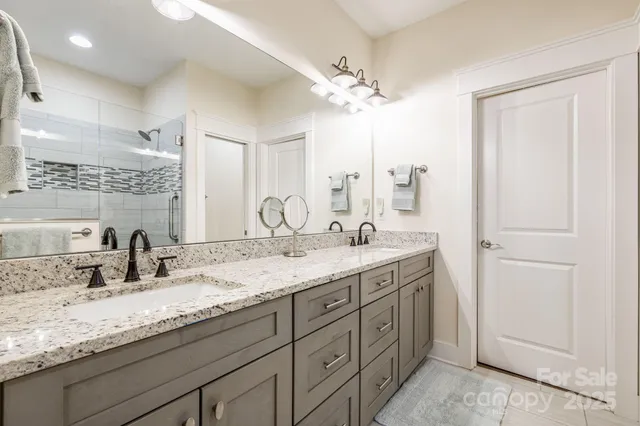 a bathroom with a granite countertop sink double and mirror