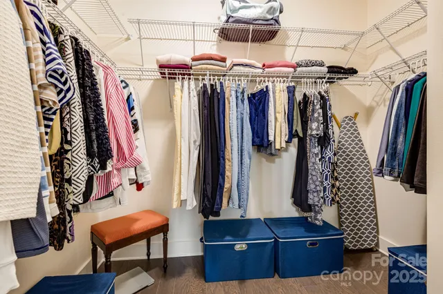 a view of walk in closet with clothes and shoes