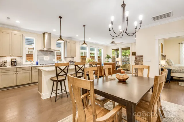 a open kitchen with stainless steel appliances granite countertop a table chairs and a view of living room