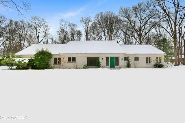 a white house with a large tree in front of it