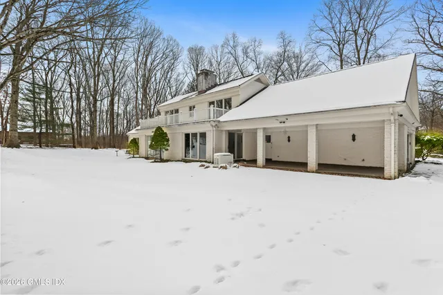 a view of house with a yard covered in snow