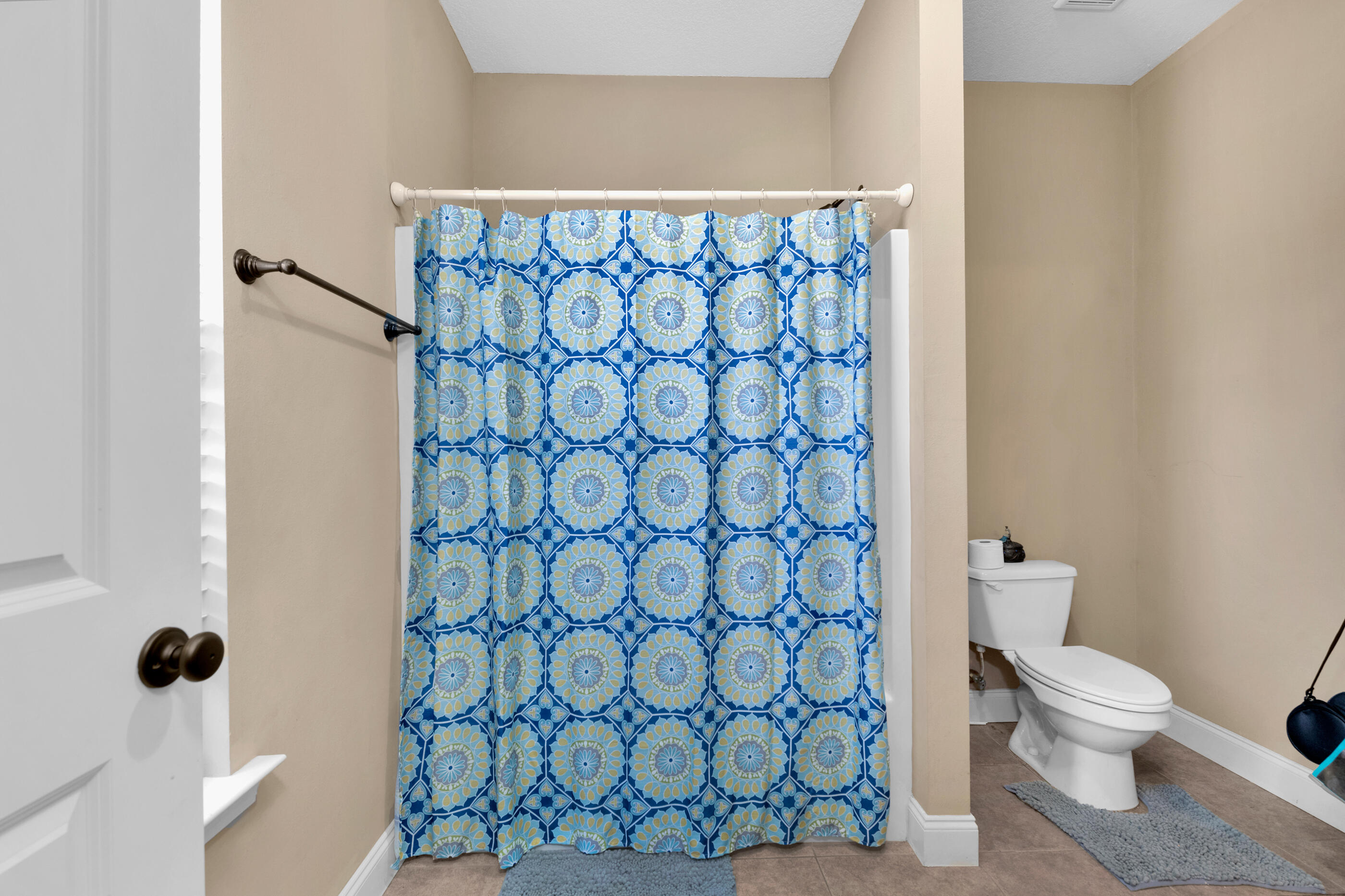 4632 Hermosa Road Crestview, FL 32539 - Photo 14 of 22 a white toilet sitting next to a shower curtain