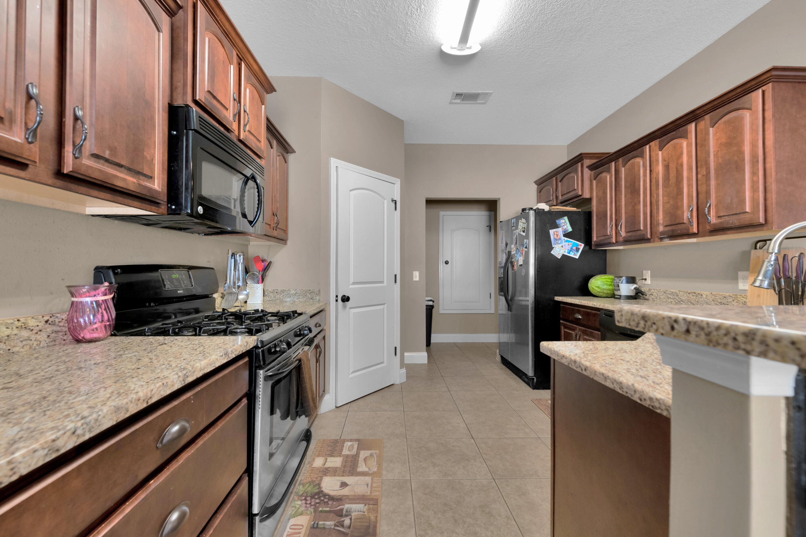 4632 Hermosa Road Crestview, FL 32539 - Photo 4 of 22 a kitchen with stainless steel appliances granite countertop a stove sink and cabinets