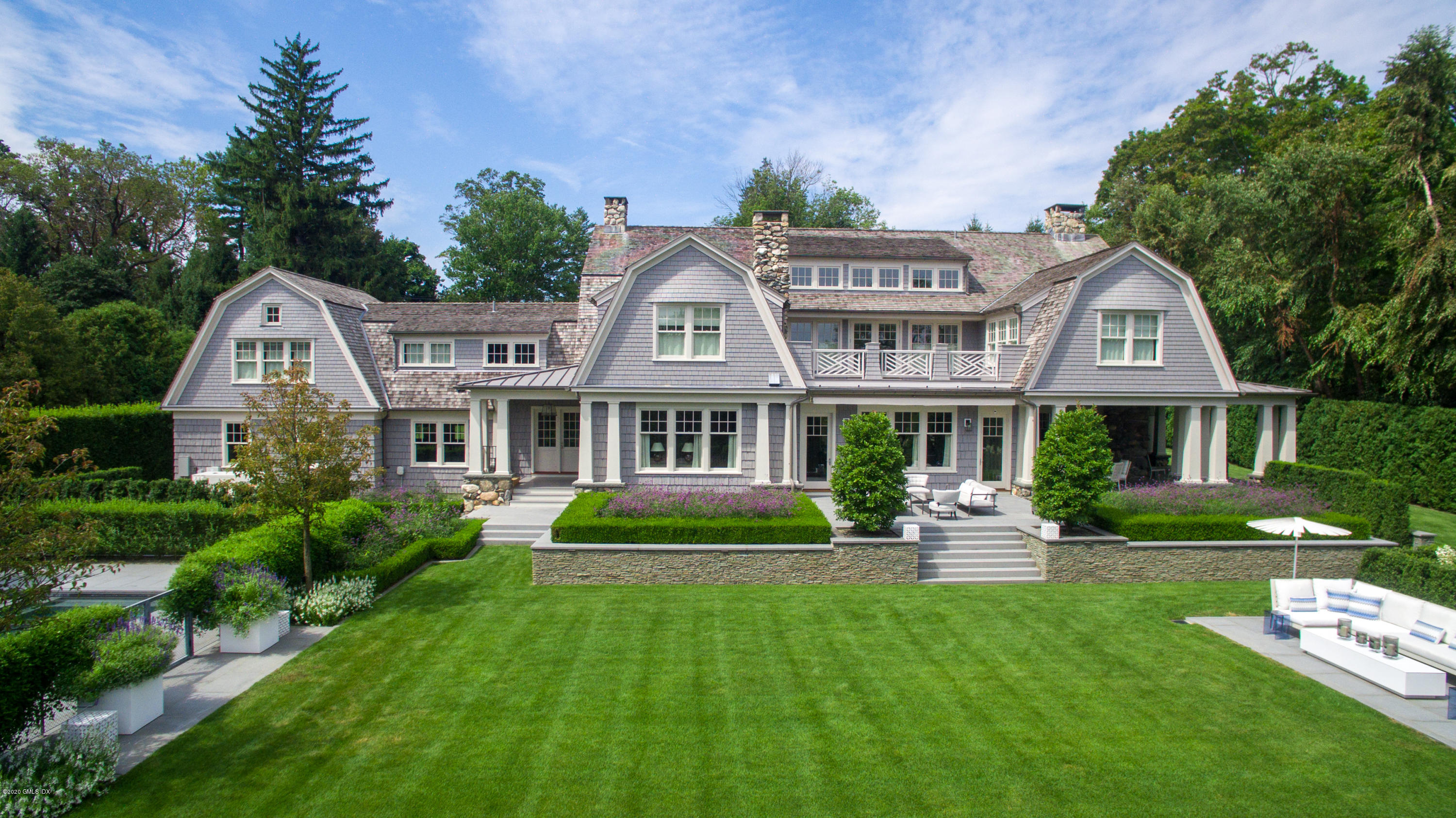 Undisclosed Address Greenwich, CT 06830 - Photo 2 of 30 a front view of a house with a garden and trees