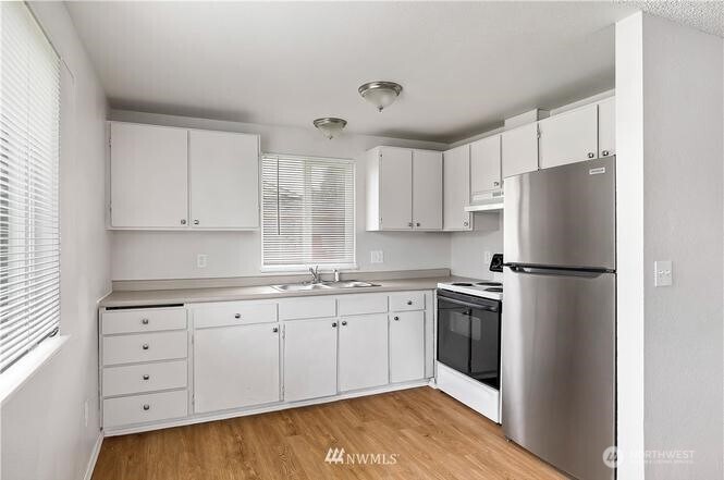 1123 Lindstrom Street Aberdeen, WA 98520 - Photo 6 of 8 a kitchen with granite countertop white cabinets and refrigerator