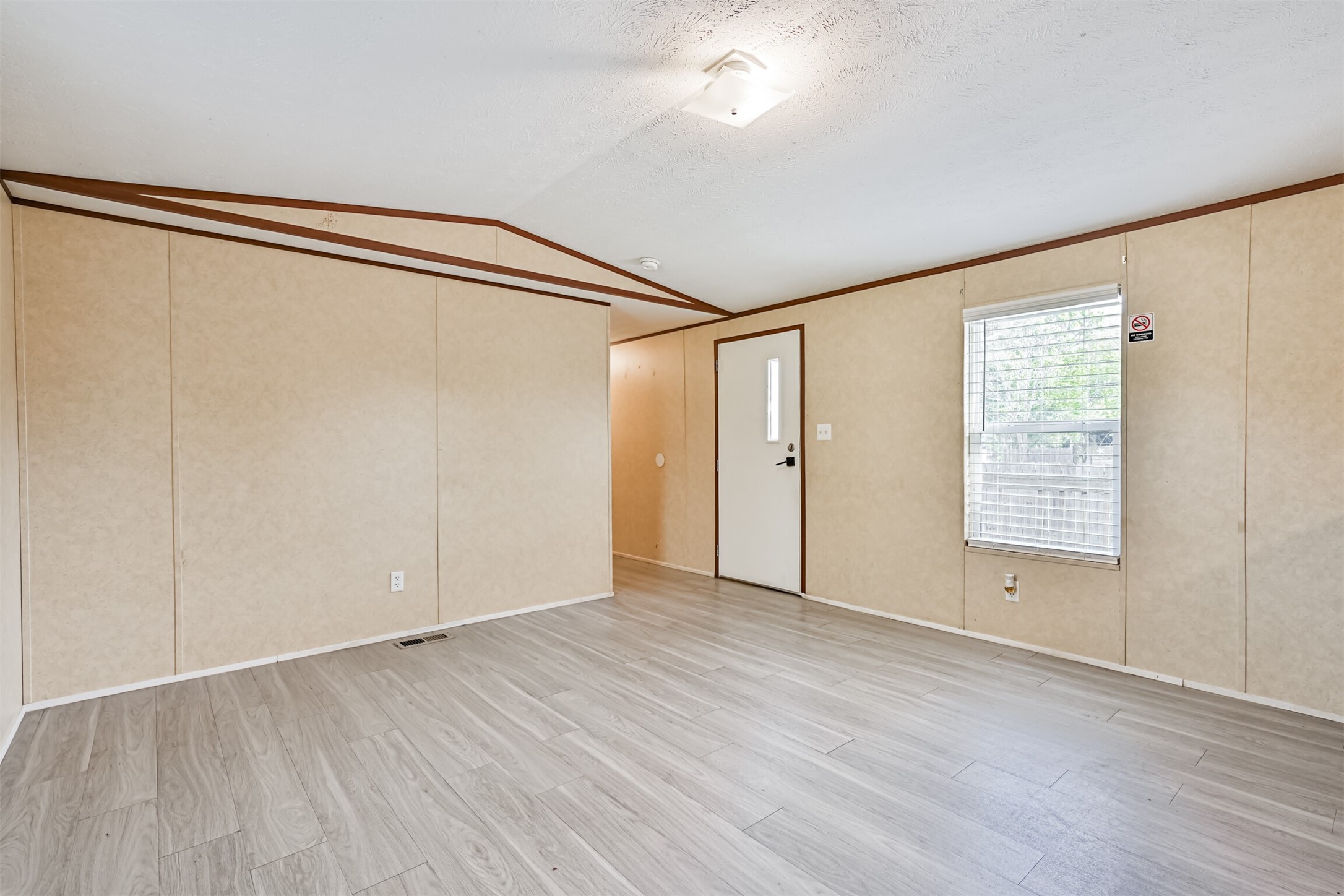 4702 10th Street Bacliff, TX 77518 - Photo 8 of 33 a view of an empty room with wooden floor and a window