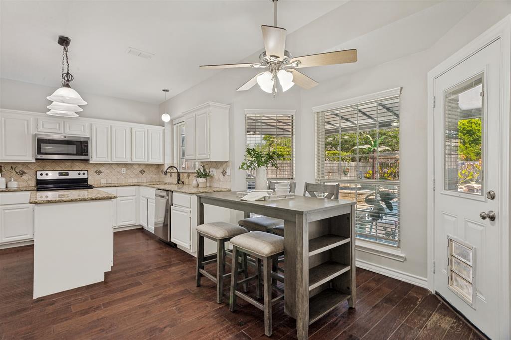 1228 Concho Drive Benbrook, TX 76126 - Photo 13 of 39 Kitchen featuring white cabinetry, granite countertops, a tile backsplash, stainless steel appliances, and dark wood-finish flooring