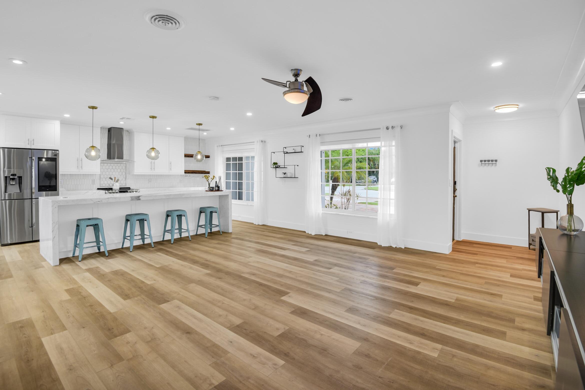701 Appleby Street Boca Raton, FL 33487 - Photo 14 of 47 a view of a kitchen with kitchen island a window wooden floor and a refrigerator