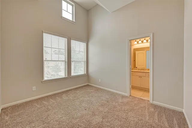 a view of an empty room with a chandelier fan