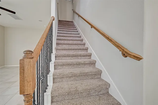 a view of an empty room with kitchen appliances and a ceiling fan