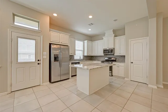 a kitchen with stainless steel appliances granite countertop a sink and a refrigerator