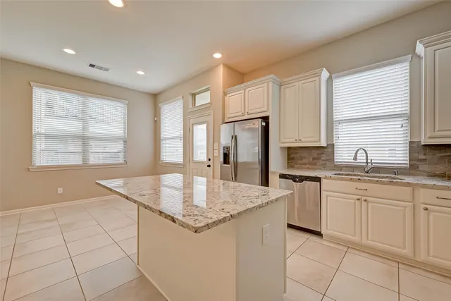 a bathroom with a granite countertop bathtub a sink and a large mirror