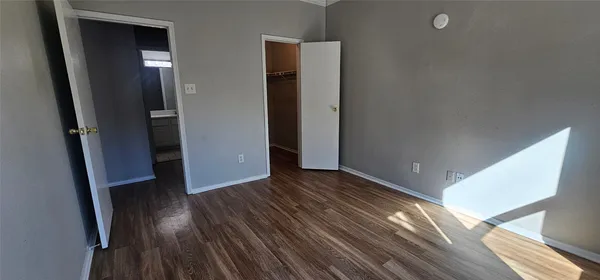 an empty room with wooden floor and entrance
