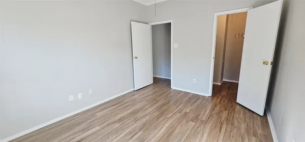 a view of a room with wooden floor and a hallway