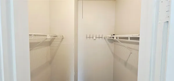 a view of walk in closet with empty racks