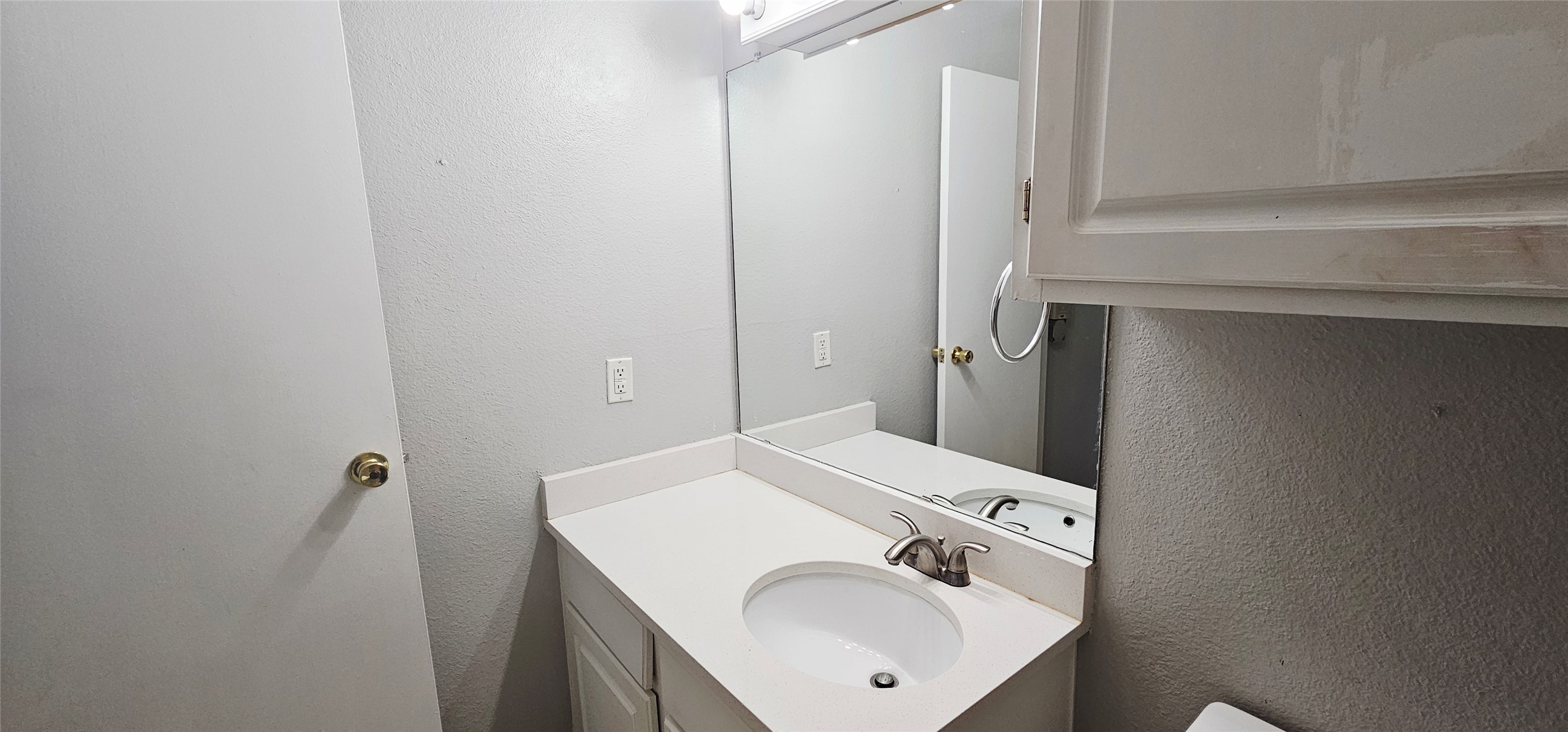 12166 Metric Boulevard, Unit 2006 Austin, TX 78758 - Photo 20 of 21 Half bathroom featuring a textured wall and vanity