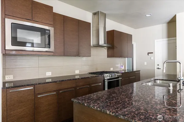a kitchen with stainless steel appliances granite countertop a sink stove and microwave
