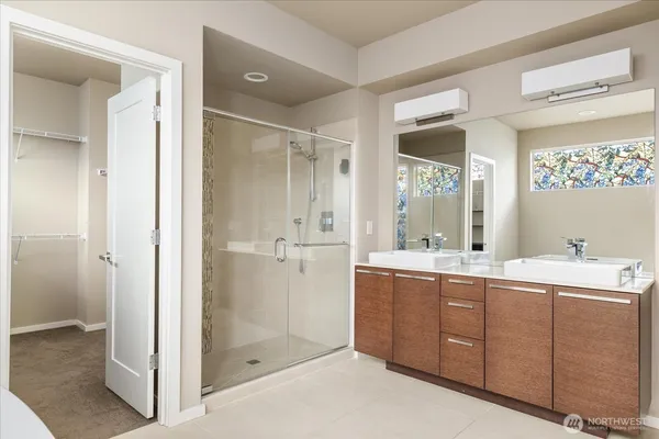 a bathroom with a double vanity sink mirror and shower