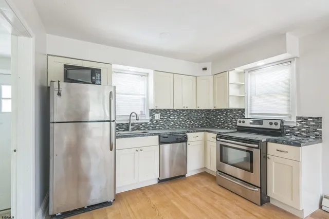 a kitchen with a stove a sink and a refrigerator