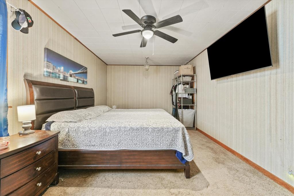 1100 North Church Street Decatur, TX 76234 - Photo 8 of 14 Carpeted room featuring a ceiling fan with integrated lighting, wood-paneled walls, and a recessed ceiling