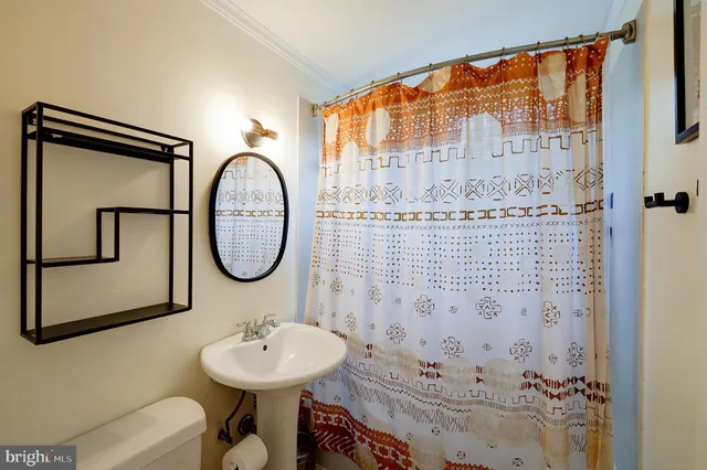 a bathroom with a sink a toilet and a mirror