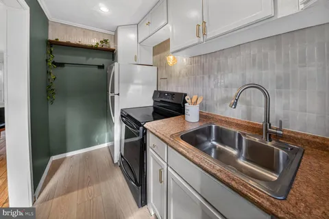 a kitchen with a refrigerator sink and cabinets