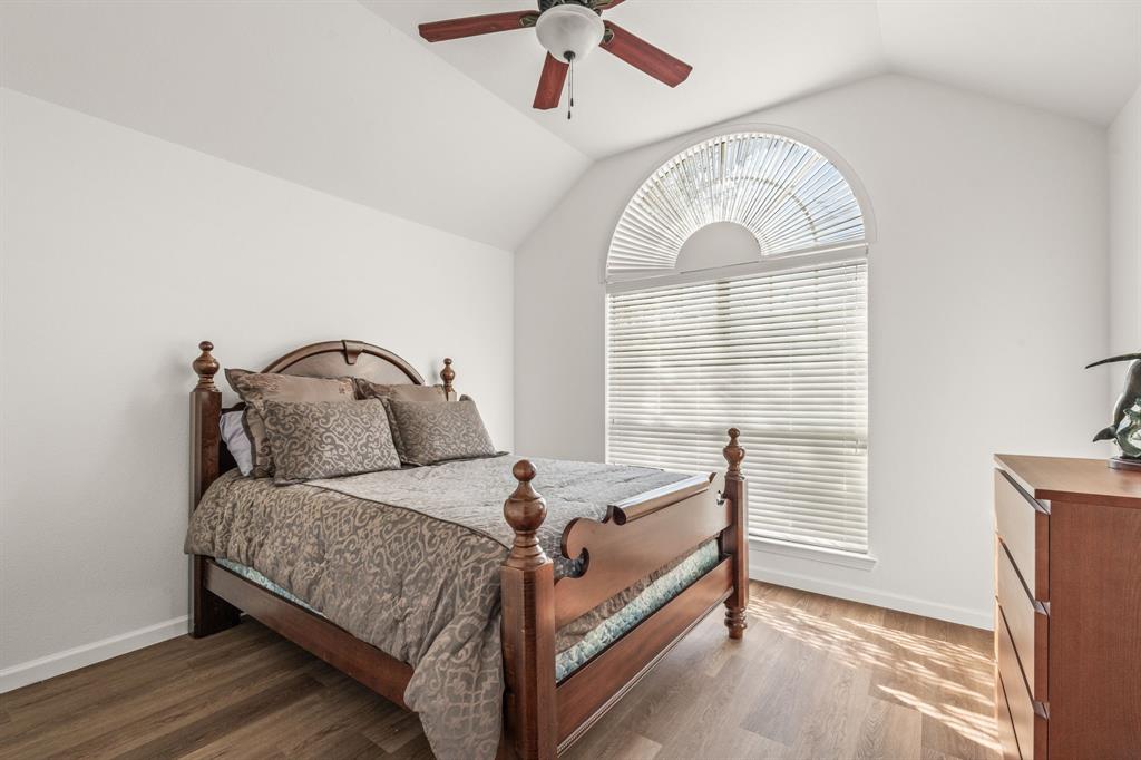 205 Crepe Myrtle Lane Murphy, TX 75094 - Photo 23 of 33 a bedroom with a bed a chandelier and a window